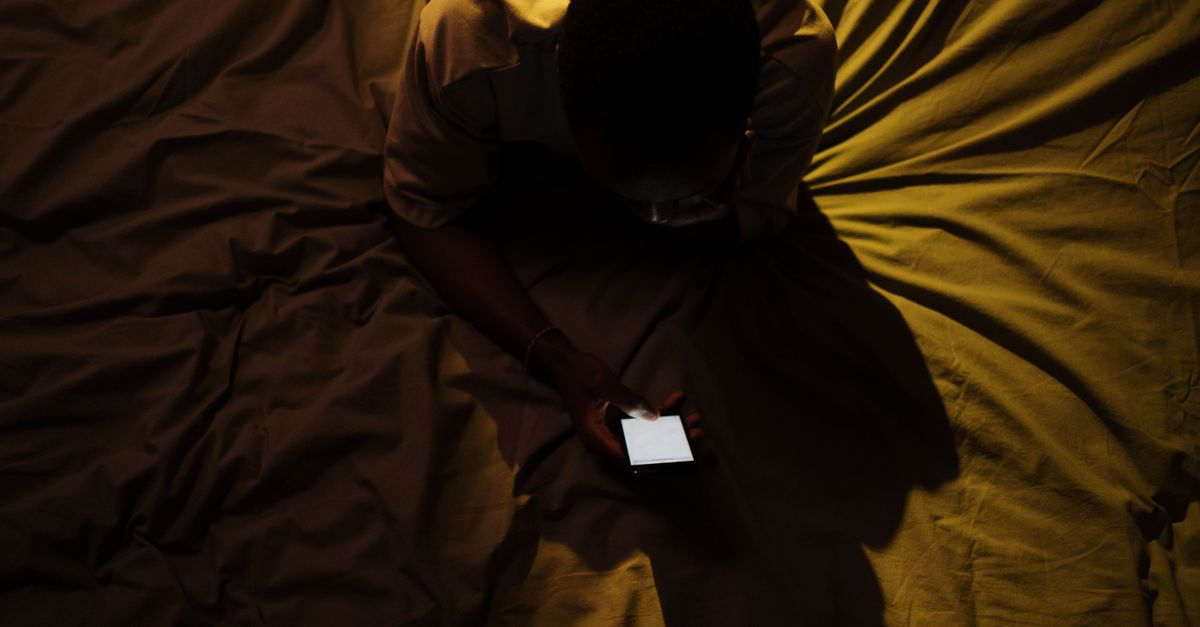 Person using a smartphone late at night in bed