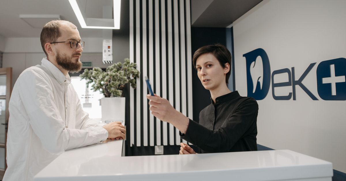 Dental receptionist answering the phone at the front desk