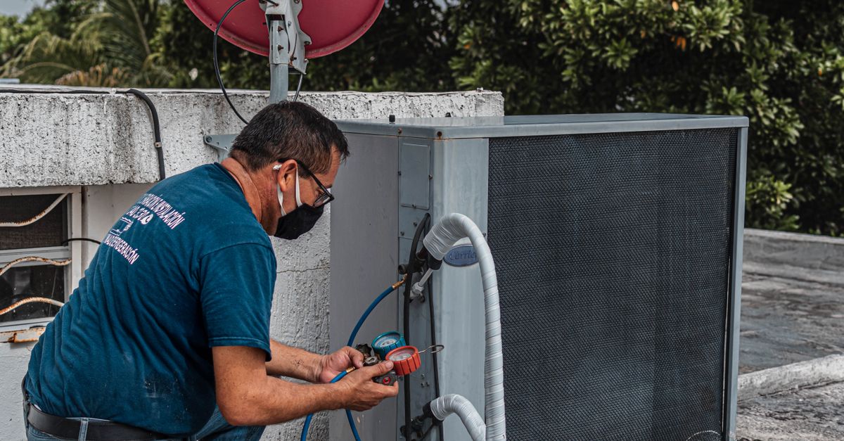 HVAC technician servicing an outdoor air conditioning unit