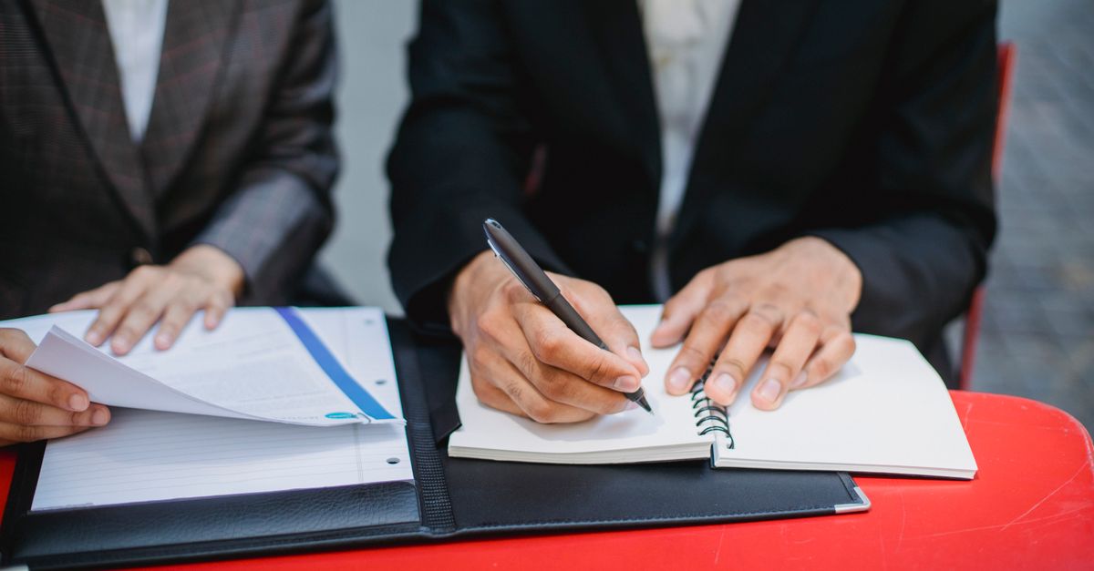 Person taking notes during a legal consultation