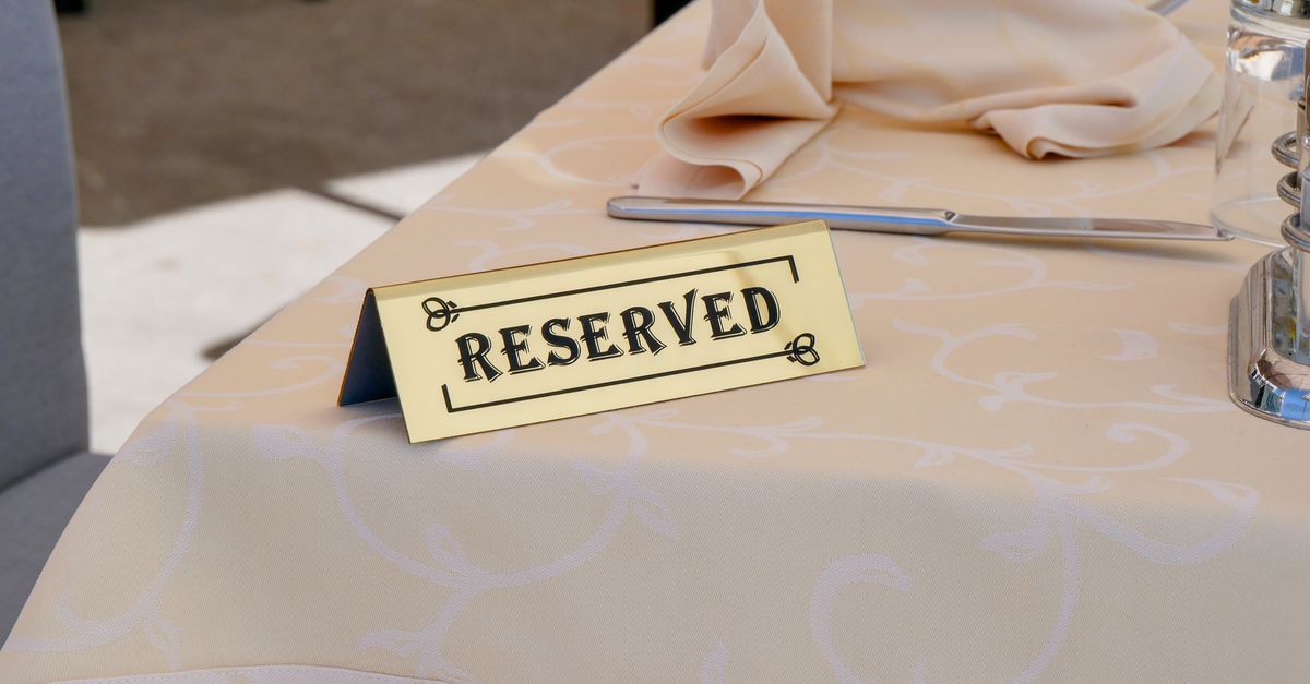 Host taking a reservation on the phone at a restaurant