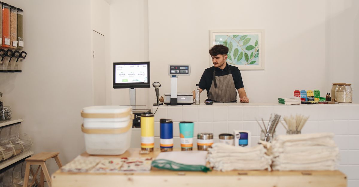 Small business owner smiling behind the counter of their shop