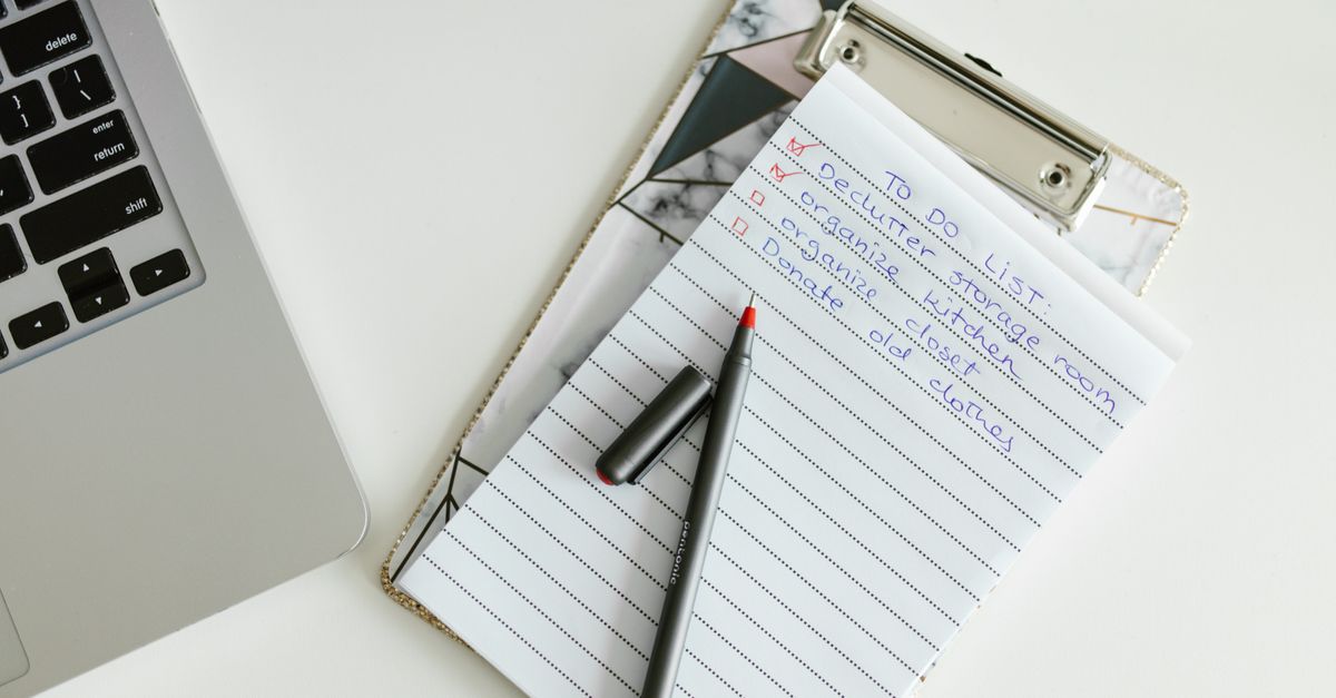 Checklist on a clipboard next to a laptop and coffee