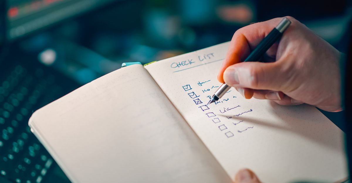 Person checking off completed tasks on a list