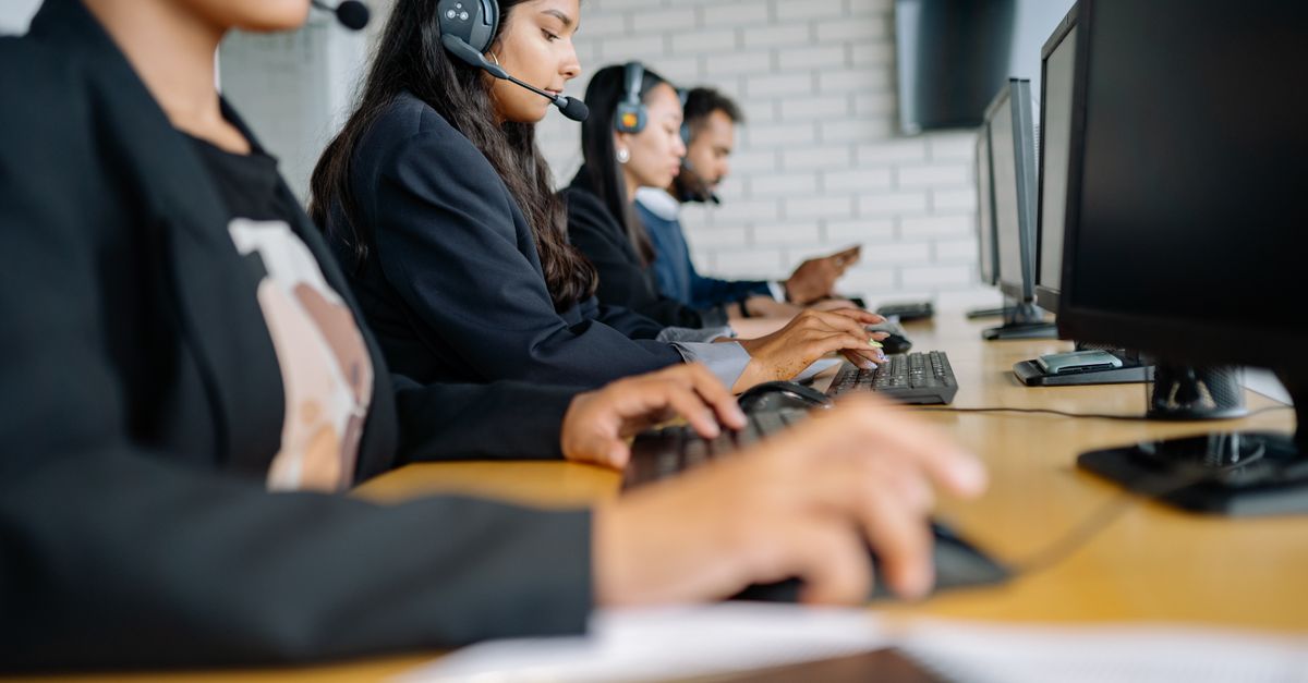 Headset resting on a keyboard in a modern workspace
